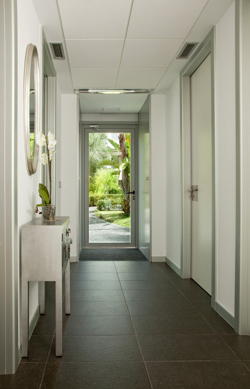 This is an example of a mid-sized scandinavian entry hall in Madrid with white walls, ceramic floors and a white front door.