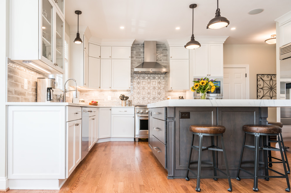Inspiration for a large transitional u-shaped light wood floor open concept kitchen remodel in Baltimore with an undermount sink, shaker cabinets, white cabinets, quartz countertops, gray backsplash, ceramic backsplash, stainless steel appliances, an island and white countertops