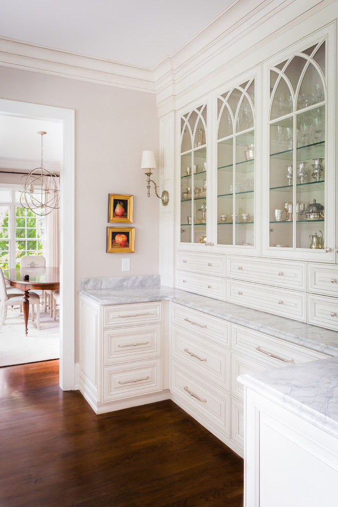Inspiration for a traditional kitchen in Raleigh with glass-front cabinets and white cabinets.