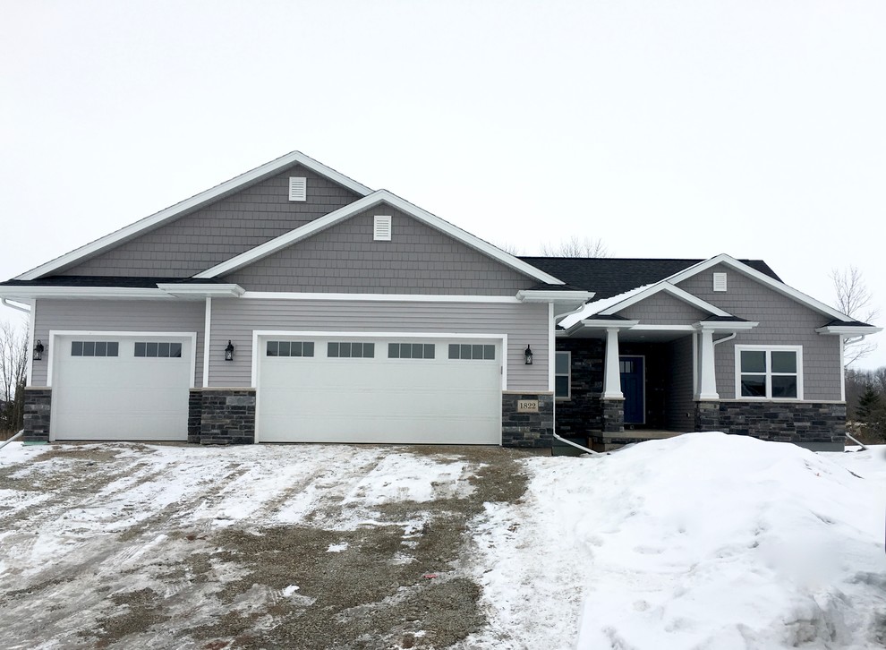 This is an example of an arts and crafts one-storey grey exterior in Other with mixed siding.