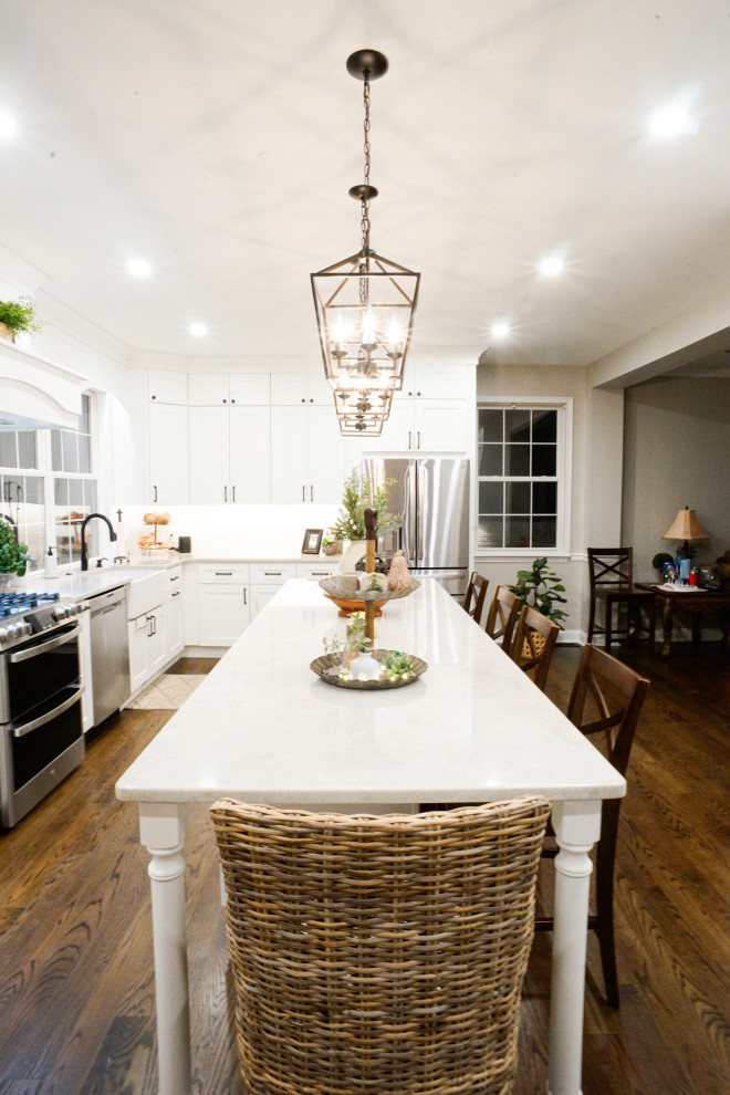 Example of a country l-shaped dark wood floor and brown floor eat-in kitchen design in Philadelphia with a farmhouse sink, shaker cabinets, white cabinets, quartzite countertops, multicolored backsplash, ceramic backsplash and an island