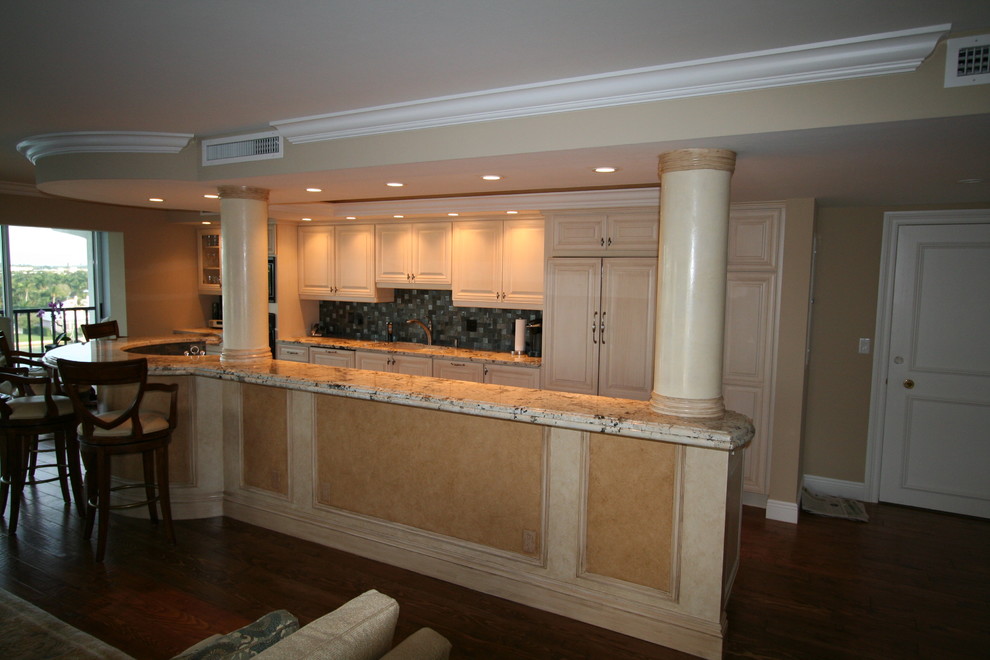 Eat-in kitchen - eat-in kitchen idea with an undermount sink, raised-panel cabinets, beige cabinets, quartzite countertops, gray backsplash, glass tile backsplash, stainless steel appliances and an island