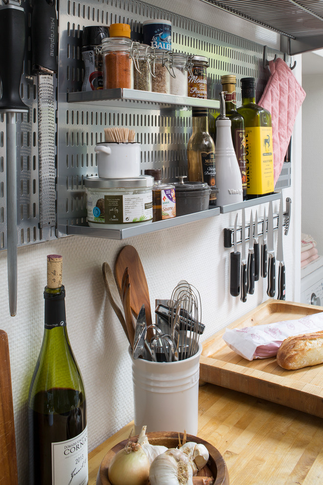 Example of a small trendy galley ceramic tile enclosed kitchen design with flat-panel cabinets, white cabinets, stainless steel countertops, white backsplash, ceramic backsplash, white appliances and no island
