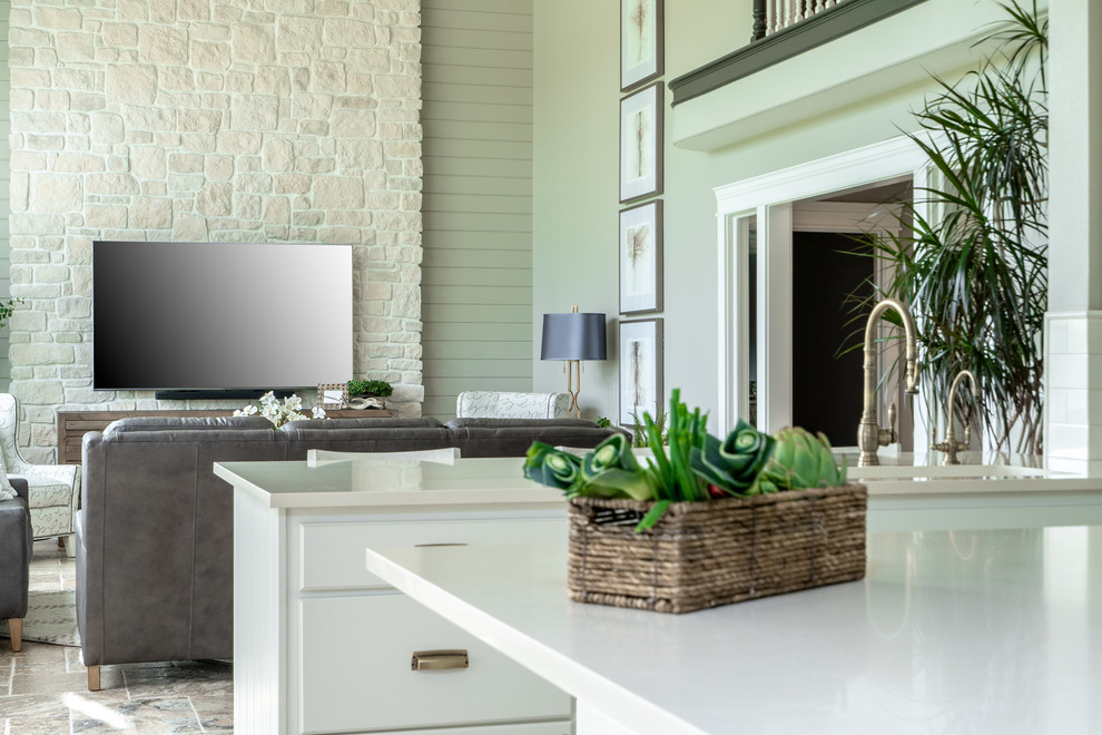 Inspiration for a transitional u-shaped travertine floor and brown floor open concept kitchen remodel in Seattle with an undermount sink, raised-panel cabinets, white cabinets, quartz countertops, white backsplash, porcelain backsplash, stainless steel appliances, an island and white countertops