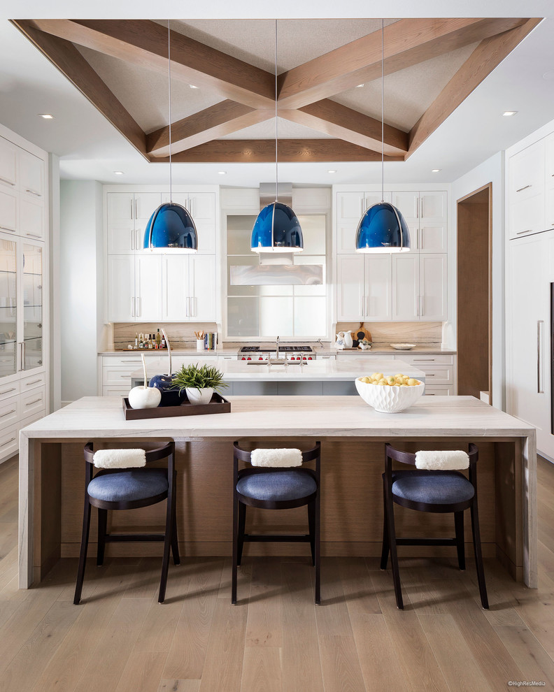 Design ideas for an expansive transitional open plan kitchen in Orlando with a drop-in sink, recessed-panel cabinets, stone slab splashback, stainless steel appliances, light hardwood floors and multiple islands.