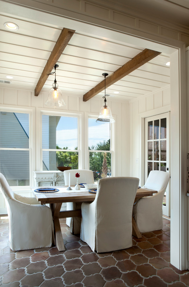 This is an example of a large beach style kitchen/dining combo in Atlanta with white walls and terra-cotta floors.