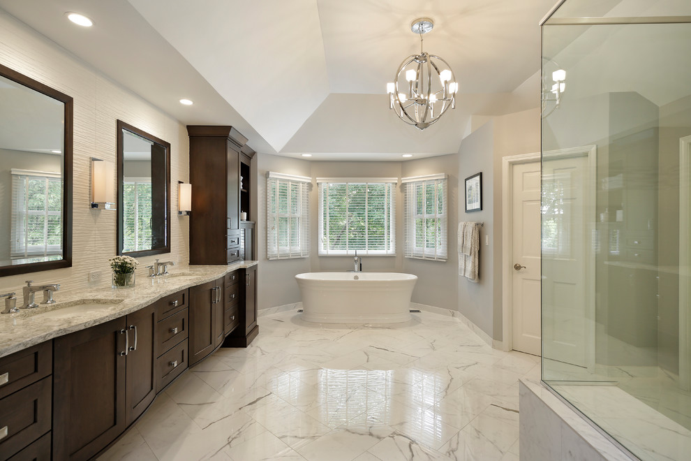 Large transitional master porcelain tile freestanding bathtub photo in Chicago with shaker cabinets, dark wood cabinets, gray walls, an undermount sink, granite countertops and a hinged shower door
