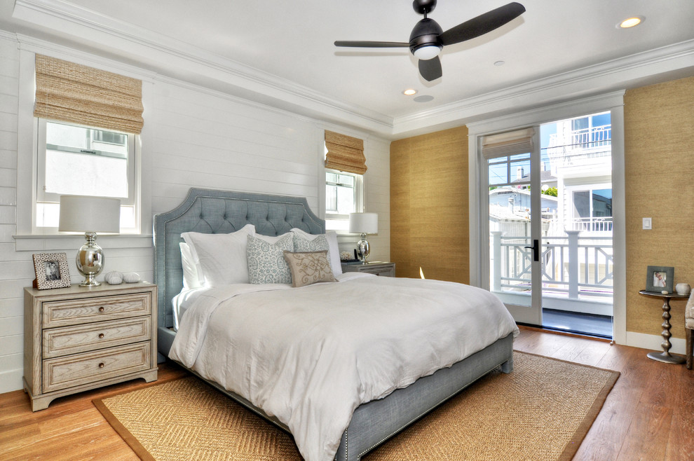 This is an example of a beach style bedroom in Los Angeles with white walls and dark hardwood floors.