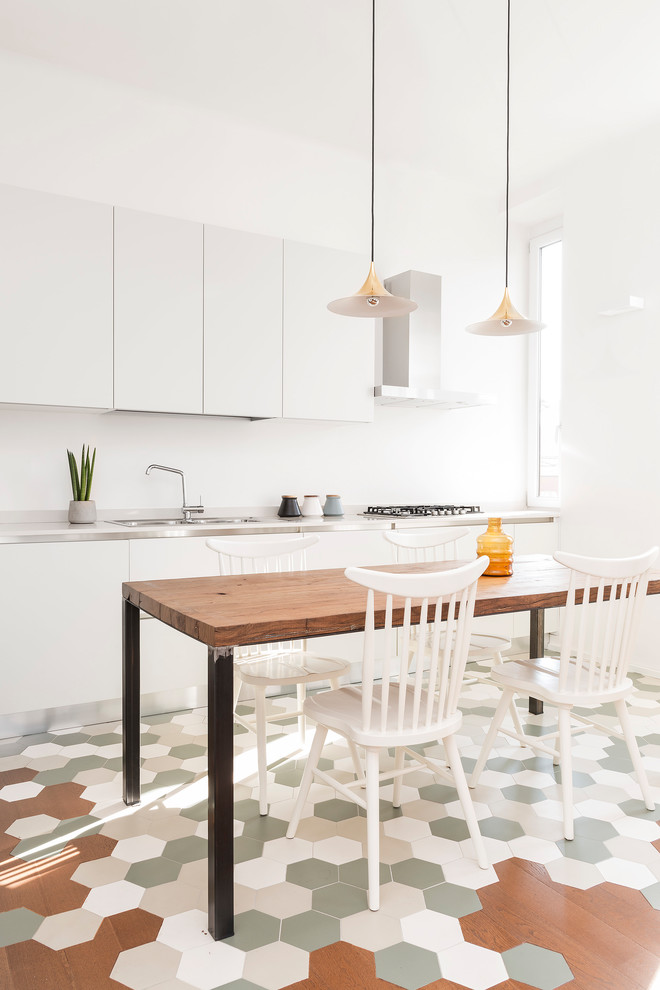 Photo of a mid-sized contemporary open plan dining in Milan with white walls, ceramic floors and green floor.