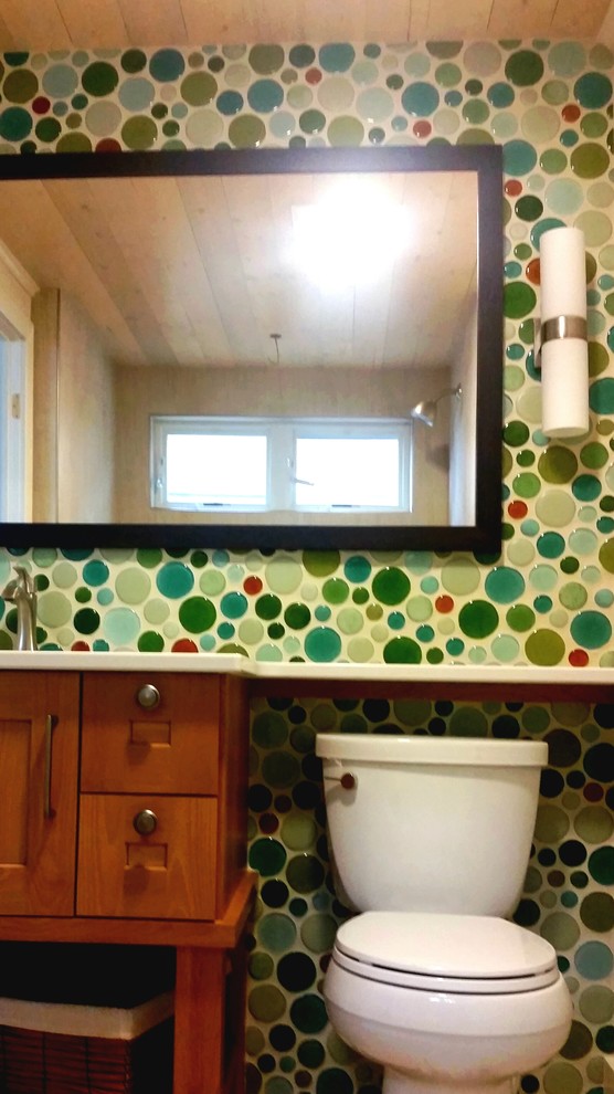 This is an example of a mid-sized eclectic 3/4 bathroom in Other with shaker cabinets, medium wood cabinets, multi-coloured tile and glass tile.
