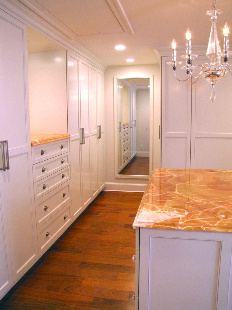 Photo of a large traditional gender-neutral walk-in wardrobe in DC Metro with shaker cabinets, white cabinets, medium hardwood floors and brown floor.