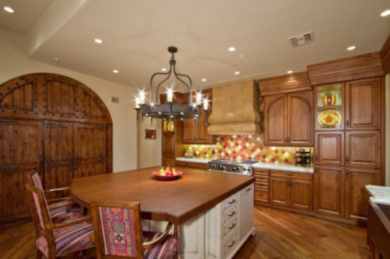 Transitional l-shaped medium tone wood floor home design photo in Phoenix with raised-panel cabinets, medium tone wood cabinets, wood countertops, multicolored backsplash, ceramic backsplash and an island