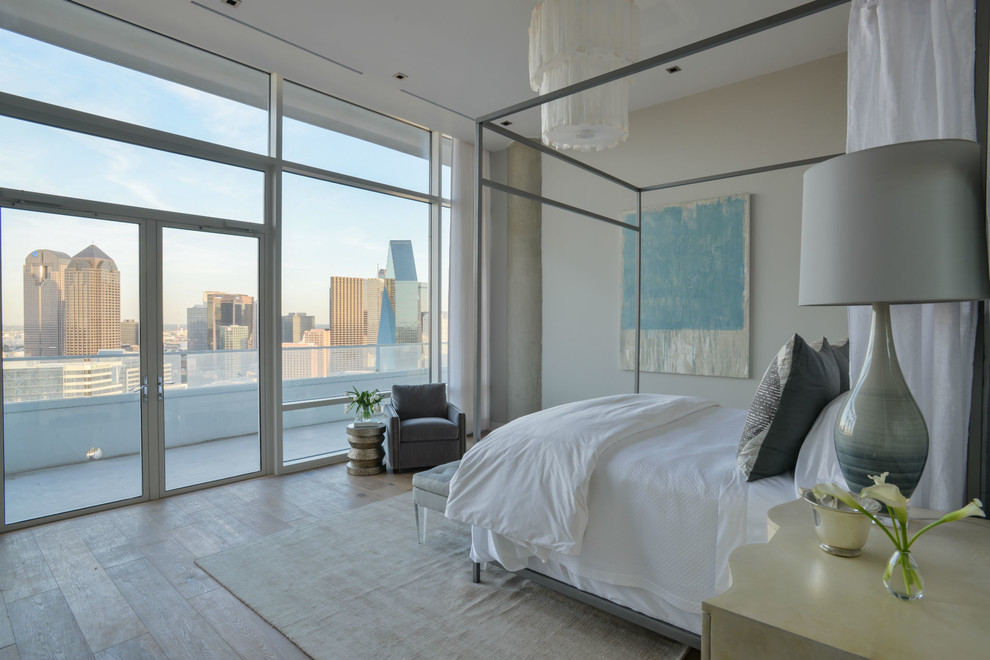 This is an example of a modern bedroom in Dallas with beige walls, light hardwood floors and no fireplace.