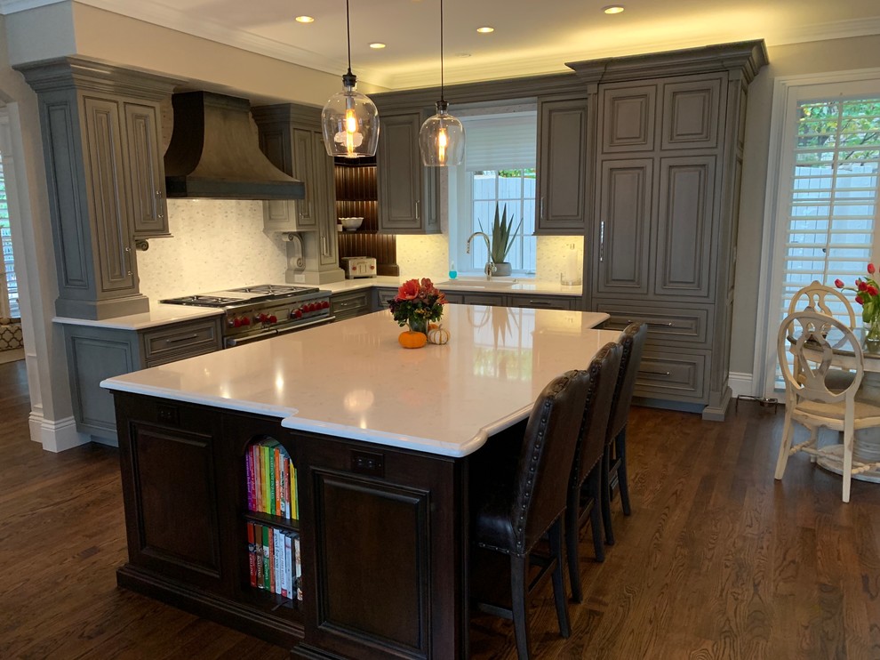 Inspiration for a transitional l-shaped medium tone wood floor and brown floor kitchen remodel in Denver with a single-bowl sink, beaded inset cabinets, gray cabinets, quartz countertops, mosaic tile backsplash, paneled appliances, an island and beige countertops