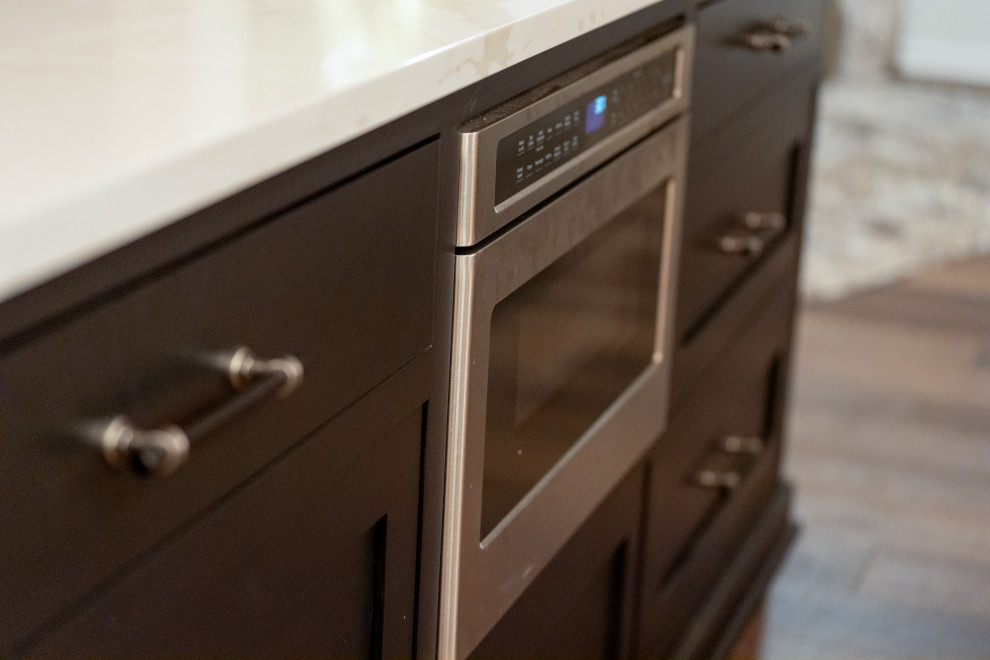 Inspiration for a large transitional l-shaped medium tone wood floor and brown floor eat-in kitchen remodel with a single-bowl sink, shaker cabinets, medium tone wood cabinets, quartz countertops, white backsplash, quartz backsplash, stainless steel appliances, an island and white countertops