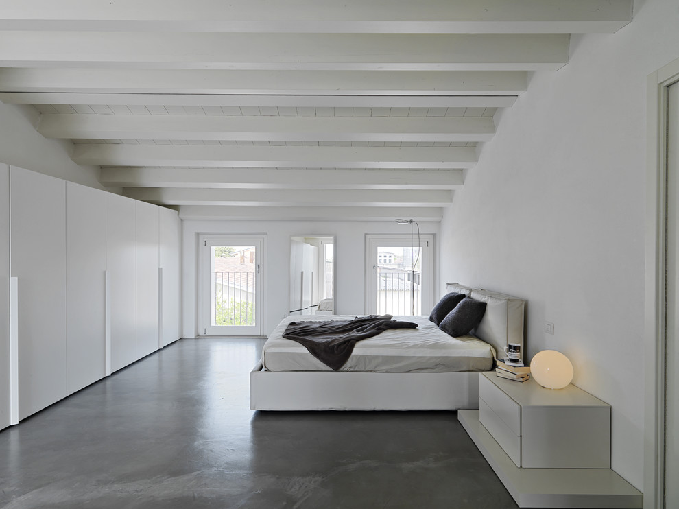 Inspiration pour une chambre parentale grise et blanche design de taille moyenne avec un mur blanc et sol en béton ciré.