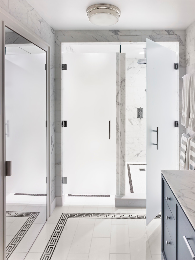 Inspiration for a contemporary bathroom in New York with flat-panel cabinets, an alcove shower, white tile, white walls, blue cabinets, marble, marble floors, white floor and a hinged shower door.