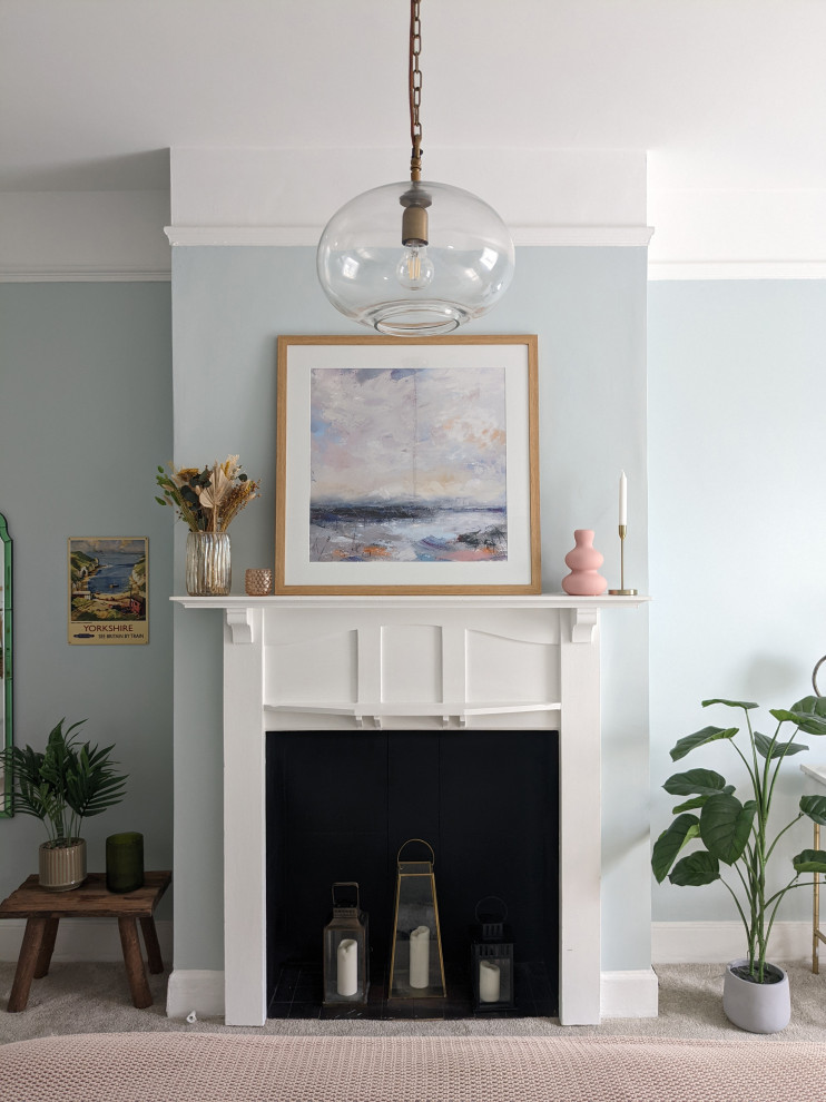 На фото: большая гостиная комната в стиле фьюжн с синими стенами, ковровым покрытием, стандартным камином, фасадом камина из дерева и бежевым полом с