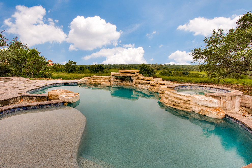 Inspiration for a large transitional backyard stone and kidney-shaped natural hot tub remodel in Austin