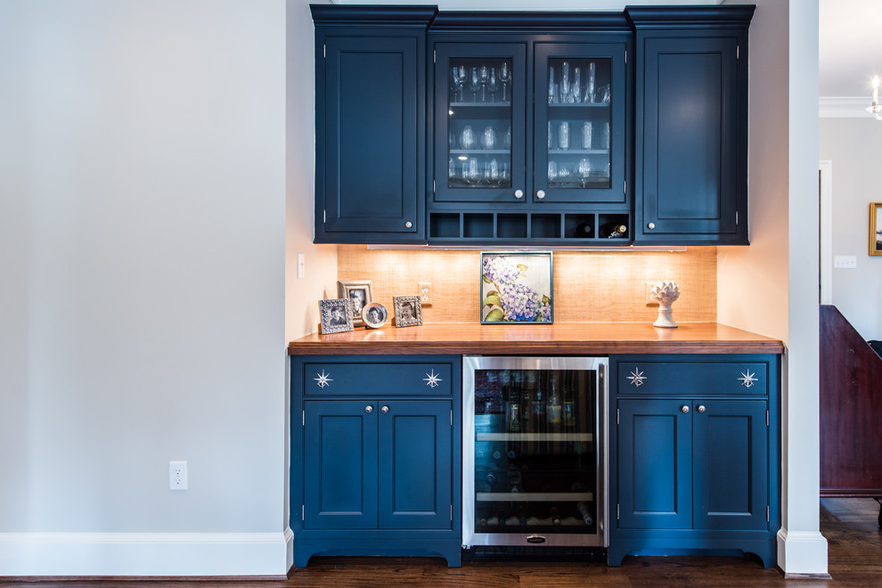 Design ideas for a mid-sized eclectic single-wall home bar in DC Metro with recessed-panel cabinets, blue cabinets, wood benchtops and beige splashback.