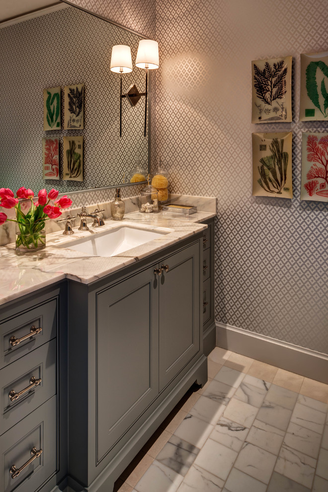 This is an example of a transitional powder room in Houston with grey cabinets, grey walls, an undermount sink, grey floor, beige benchtops, recessed-panel cabinets and marble benchtops.