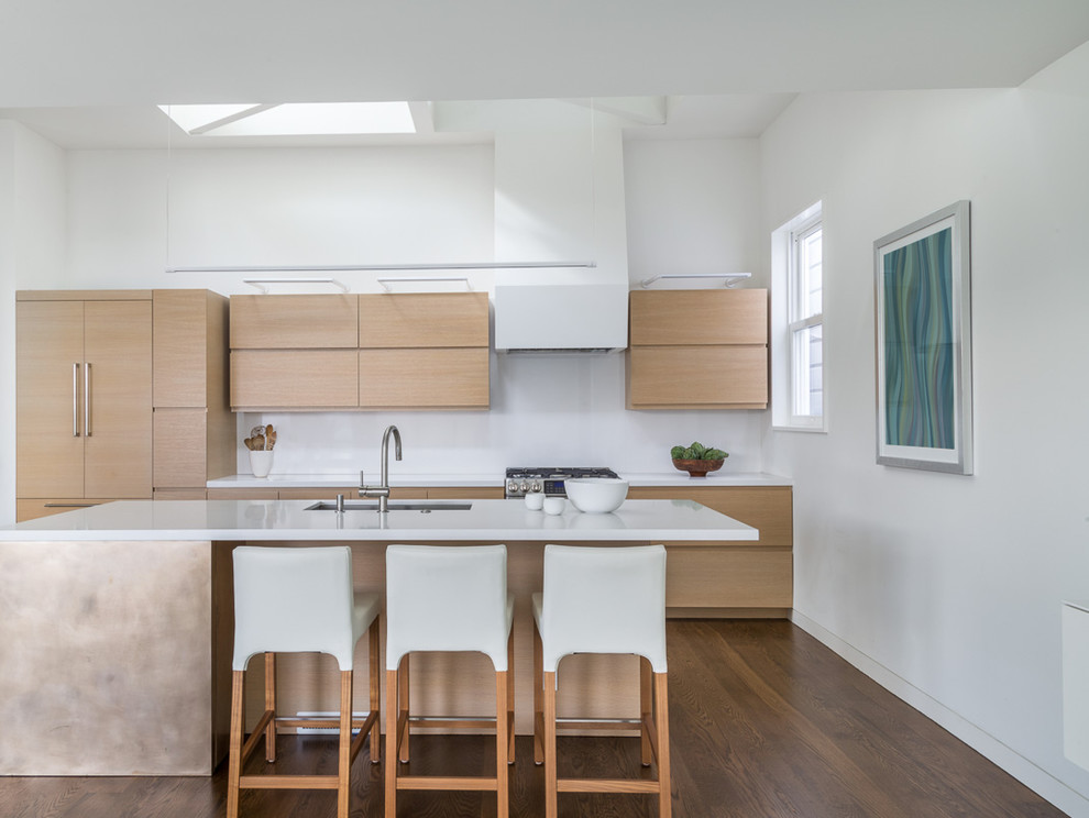 Mid-sized modern open plan kitchen in San Francisco with an integrated sink, flat-panel cabinets, light wood cabinets, quartzite benchtops, white splashback, panelled appliances, dark hardwood floors and a peninsula.