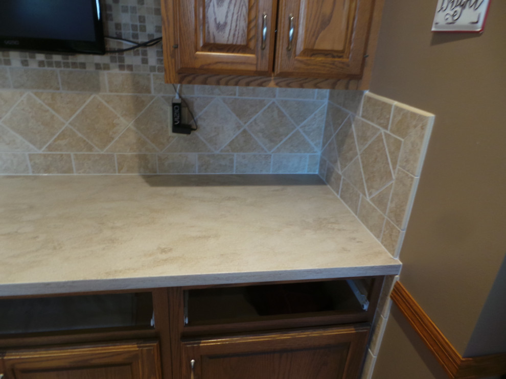 Inspiration for a large contemporary l-shaped light wood floor and brown floor enclosed kitchen remodel with an undermount sink, raised-panel cabinets, medium tone wood cabinets, solid surface countertops, beige backsplash, ceramic backsplash, stainless steel appliances, an island and beige countertops