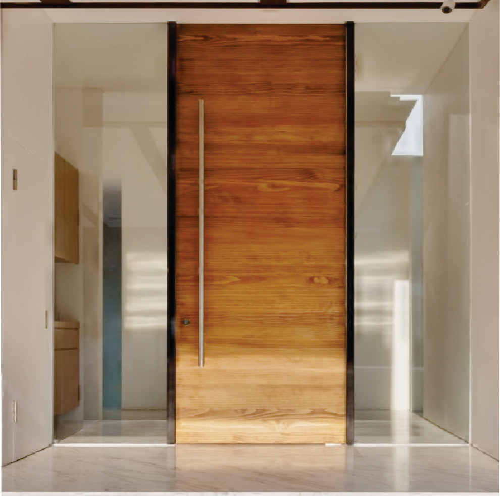 This is an example of a modern front door in Miami with a single front door and a medium wood front door.