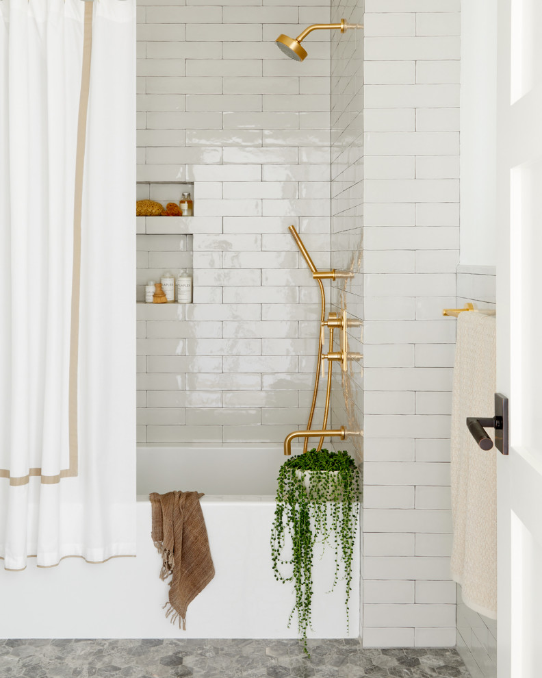 ニューヨークにあるトランジショナルスタイルのおしゃれな浴室 (アルコーブ型浴槽、シャワー付き浴槽	、ベージュのタイル、グレーの床、シャワーカーテン、ニッチ) の写真