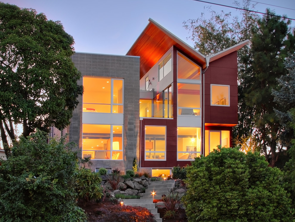 Design ideas for a contemporary two-storey red exterior in Seattle with mixed siding and a butterfly roof.