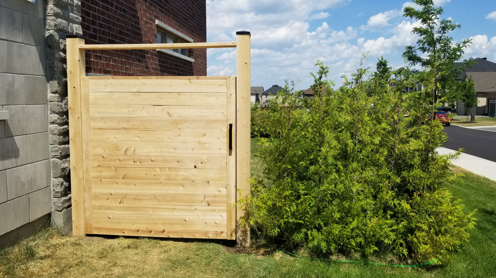 This is an example of a mid-sized modern side yard full sun garden in Ottawa with with a gate.