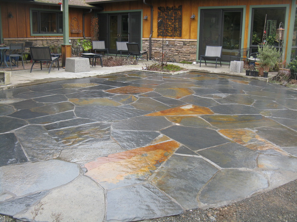 Mid-sized eclectic backyard patio in Portland with natural stone pavers.