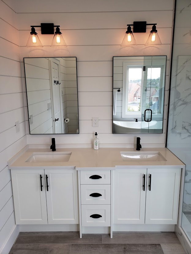 Design ideas for a mid-sized country master bathroom in Toronto with shaker cabinets, white cabinets, a freestanding tub, a corner shower, a two-piece toilet, black and white tile, porcelain tile, white walls, porcelain floors, an undermount sink, engineered quartz benchtops, grey floor and white benchtops.