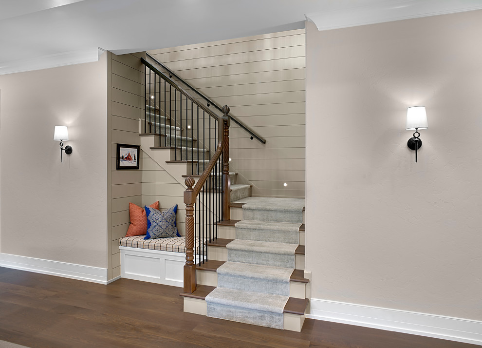 Mid-sized traditional wood u-shaped staircase in Grand Rapids with wood risers, wood railing and planked wall panelling.