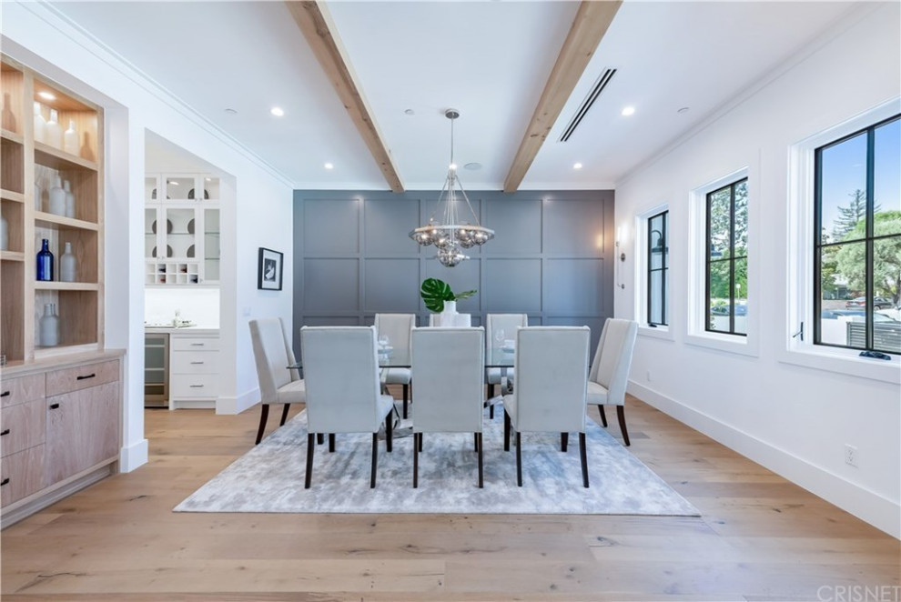 This is an example of a large modern kitchen/dining combo in Los Angeles with grey walls, light hardwood floors, no fireplace, brown floor, exposed beam and decorative wall panelling.