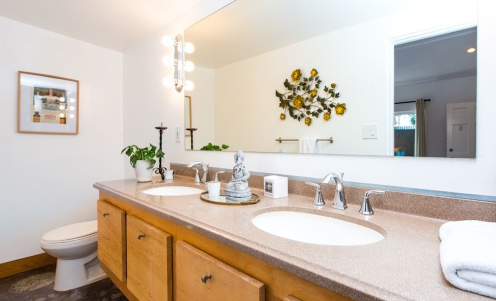 Photo of a small modern master bathroom in Los Angeles with beaded inset cabinets, light wood cabinets, a one-piece toilet, white tile, white walls, porcelain floors, a wall-mount sink, terrazzo benchtops, multi-coloured floor and pink benchtops.