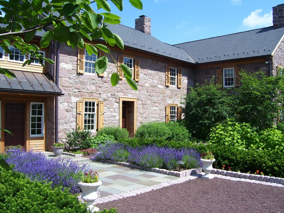 Large country two-storey exterior in Philadelphia with stone veneer.