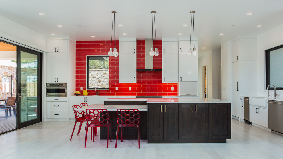 Inspiration for a huge contemporary beige floor kitchen remodel in Denver with flat-panel cabinets, white cabinets, quartzite countertops, red backsplash, subway tile backsplash, stainless steel appliances, white countertops, a farmhouse sink and an island