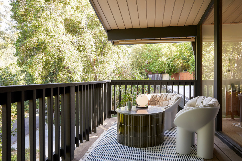 This is an example of a small midcentury private wood railing balcony in San Francisco with a roof extension.