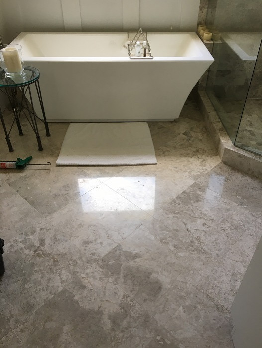 This is an example of a mid-sized traditional master bathroom in Atlanta with shaker cabinets, white cabinets, a freestanding tub, a corner shower, a one-piece toilet, gray tile, stone tile, brown walls, marble floors, an undermount sink, quartzite benchtops, grey floor, an open shower, white benchtops, a shower seat, a double vanity, a built-in vanity, coffered and panelled walls.