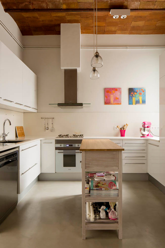 Photo of a mid-sized industrial u-shaped separate kitchen in Other with white cabinets, concrete floors, with island, grey floor, white splashback, an undermount sink, flat-panel cabinets and stainless steel appliances.