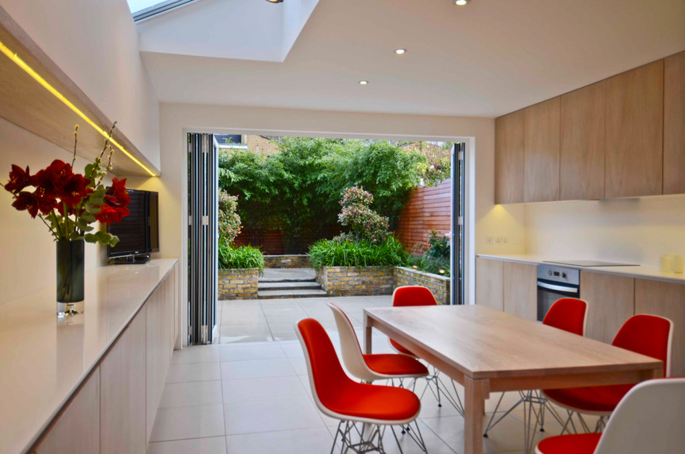 Contemporary eat-in kitchen in London with flat-panel cabinets and light wood cabinets.