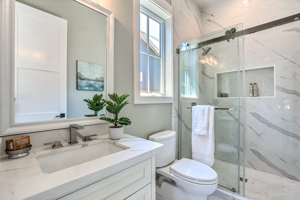 Источник вдохновения для домашнего уюта: маленькая ванная комната в стиле кантри с фасадами в стиле шейкер, белыми фасадами, душем в нише, унитазом-моноблоком, белой плиткой, керамогранитной плиткой, серыми стенами, мраморным полом, душевой кабиной, врезной раковиной, столешницей из искусственного кварца, белым полом, душем с раздвижными дверями, белой столешницей, тумбой под одну раковину и встроенной тумбой для на участке и в саду