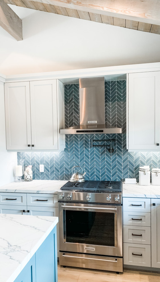 This is an example of a medium sized beach style u-shaped kitchen in Orange County with shaker cabinets, grey cabinets, quartz worktops, blue splashback, glass tiled splashback, stainless steel appliances, light hardwood flooring, an island, white worktops and a wood ceiling.