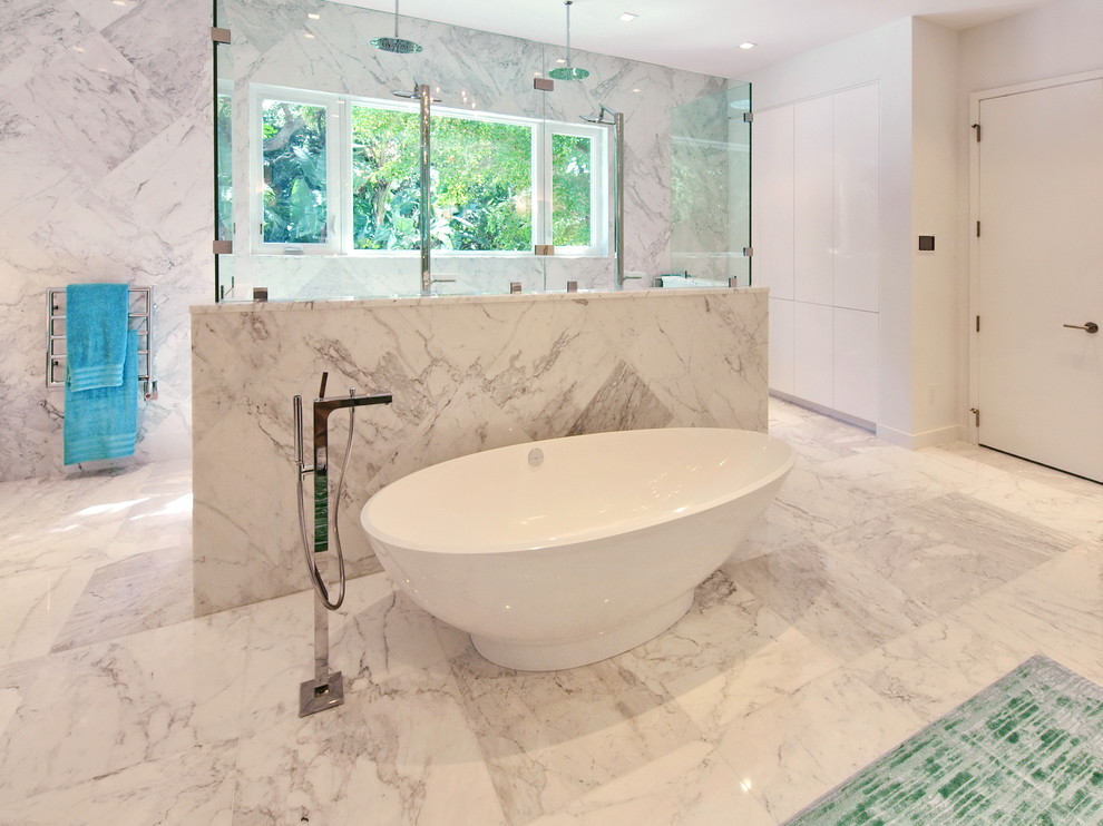 Photo of an expansive modern master bathroom in Tampa with flat-panel cabinets, white cabinets, a freestanding tub, a double shower, white tile, stone tile, white walls, marble floors, a vessel sink and marble benchtops.