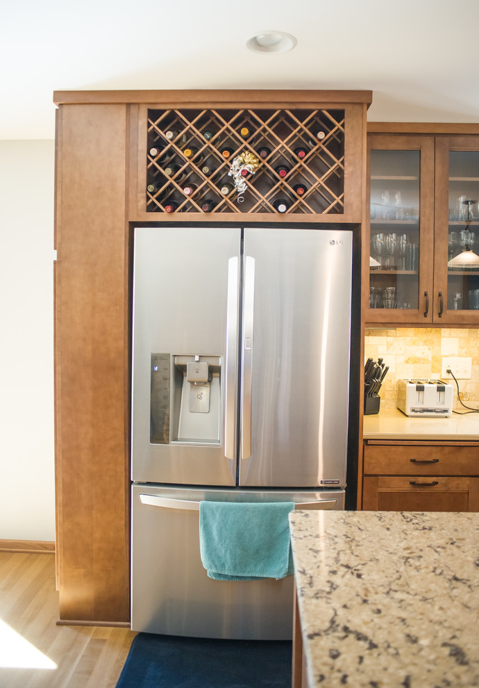 Open concept kitchen - large transitional l-shaped light wood floor open concept kitchen idea with an undermount sink, recessed-panel cabinets, medium tone wood cabinets, quartz countertops, beige backsplash, stainless steel appliances and an island