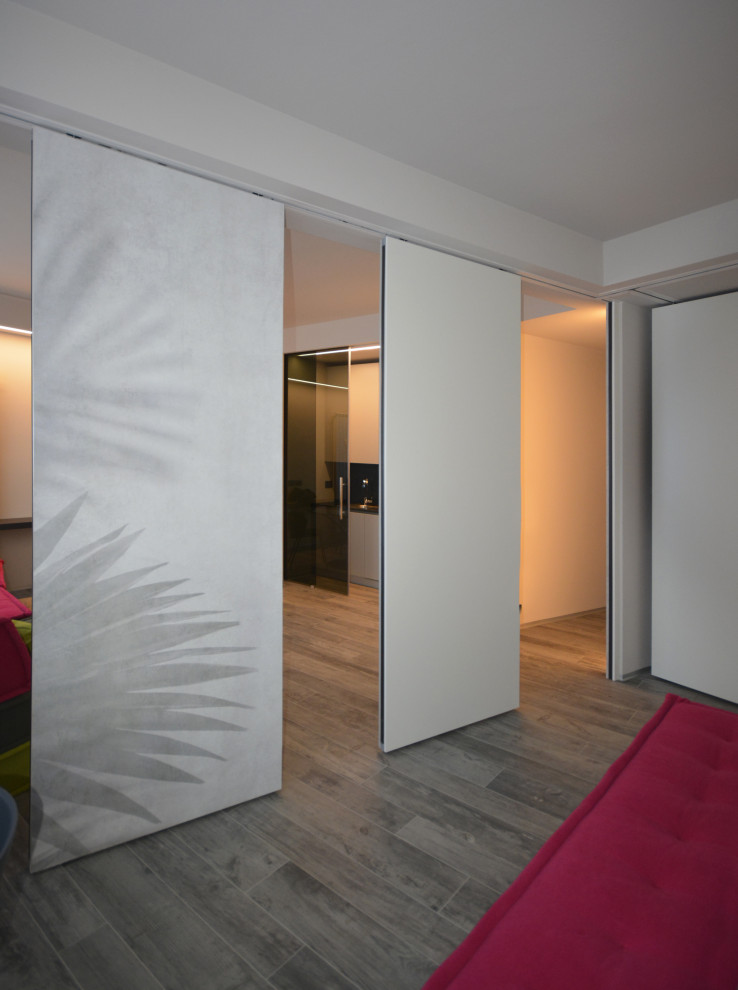 Exemple d'un petit salon tendance ouvert avec un mur gris, un sol en carrelage de porcelaine, un téléviseur fixé au mur, un sol gris et du papier peint.