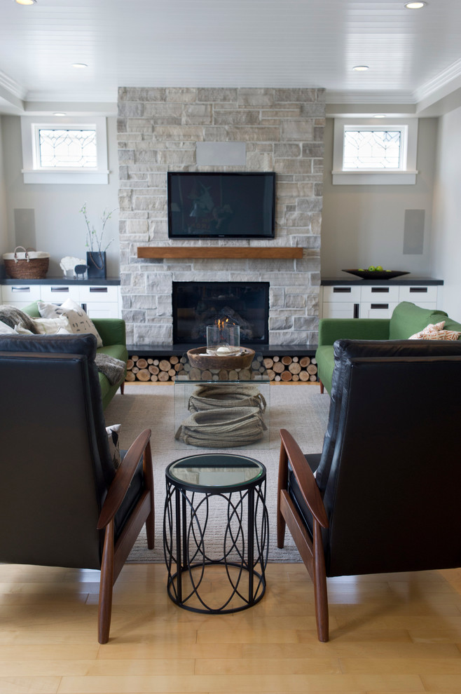 Design ideas for a mid-sized transitional family room in Toronto with grey walls, light hardwood floors, a standard fireplace, a stone fireplace surround and a wall-mounted tv.