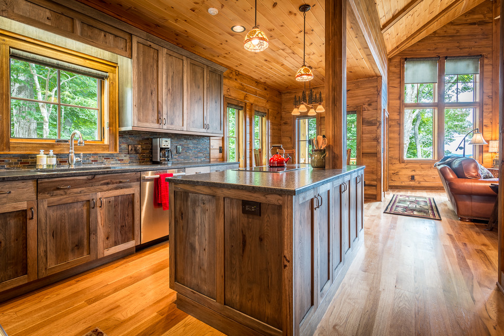 Inspiration for a mid-sized rustic l-shaped medium tone wood floor and brown floor eat-in kitchen remodel in Charlotte with an undermount sink, shaker cabinets, dark wood cabinets, granite countertops, multicolored backsplash, glass tile backsplash, stainless steel appliances and an island