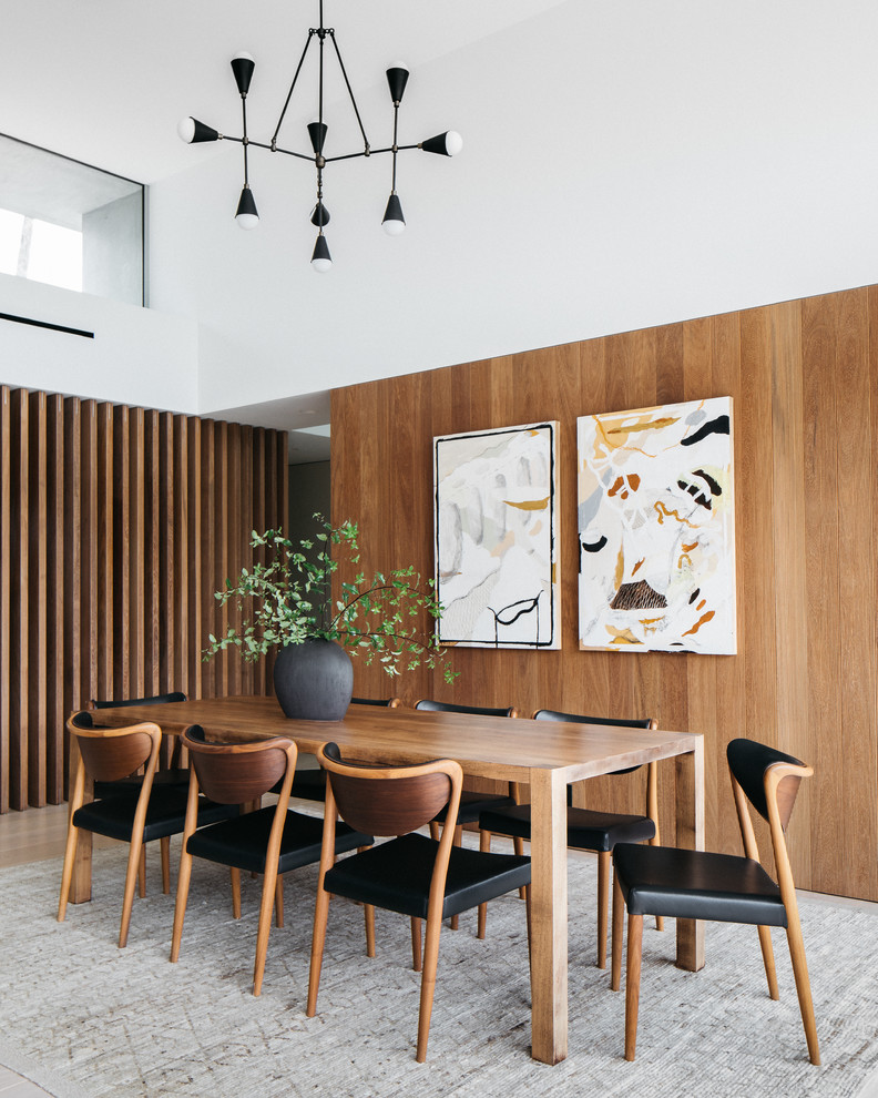 This is an example of a contemporary dining room in Los Angeles with white walls, light hardwood floors and beige floor.